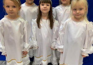 Uroczystość Choinkowa. Dziewczynki w białych sukniach i z aureolą na głowie - praebrane za aniołki.