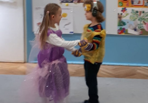 Eco bal karnawałowy. Dwoje dzieci tańczy w parze, zostali wybrani na króla i królową balu.