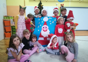 Na zdjęciu widać grupę dzieci z wykonanym wspólnie plakatem Świętego Mikołaja.