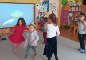 W świecie kosmosu - dzieci tańczą na dywanie do interaktywnej piosenki o kosmosie.