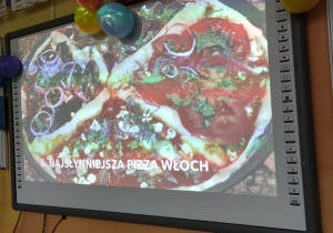 Dzień Pizzy - na tablicy multimedialnej prezentowana jest przygotowana pizza.
