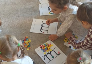 Na zdjęciu widać grupę dzieci poznającą literkę "m".