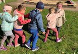 W Sherborne w grupie I. zajęcia w ogrodzie. Dzieci ustawione w pociąg trzymają się za ramiona.